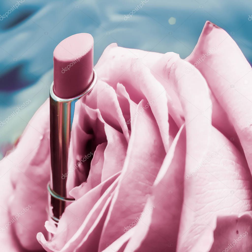 Pink lipstick and rose flower on liquid background, waterproof g