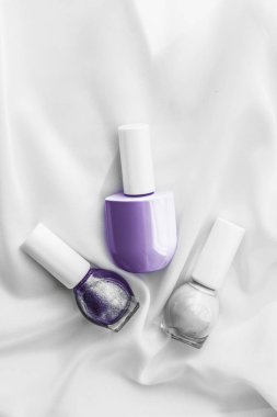 İpek arka planda oje şişeleri, Fransız manikür ürünleri.