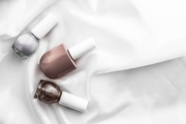 İpek arka planda oje şişeleri, Fransız manikür ürünleri.