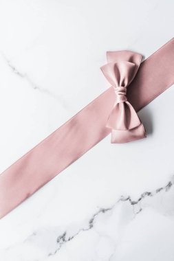 Bej ipek kurdele ve mermer arka planda fiyonk, cazibe mevcut 