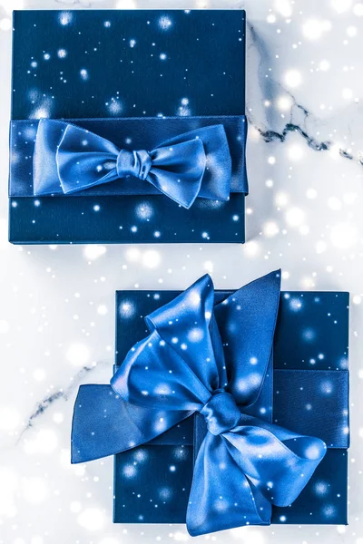 冬季节日礼品盒，蓝色丝质蝴蝶结，雪在大理石上闪闪发光 — 图库照片