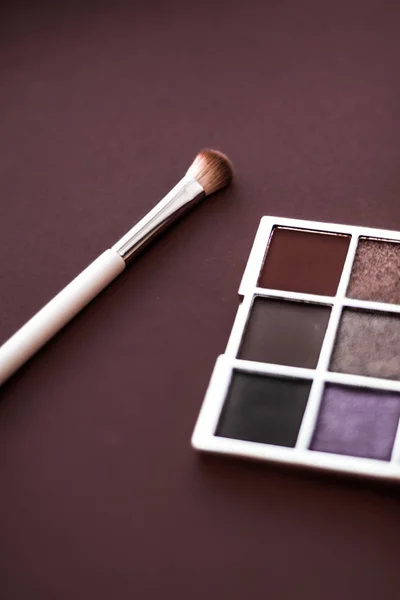 Eyeshadow palette and make-up brush on chocolate background, eye — Stock Photo, Image