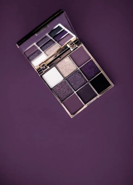 Eyeshadow palette and make-up brush on purple background, eye sh