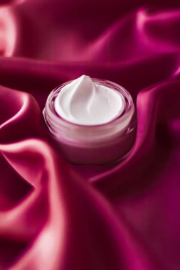 Face cream moisturizer jar on silk background, moisturizing skin clipart