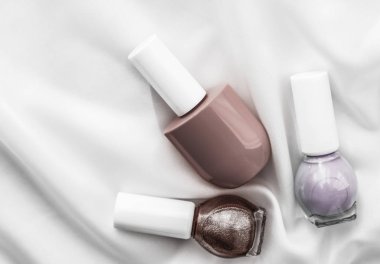 İpek arka planda oje şişeleri, Fransız manikür ürünleri.