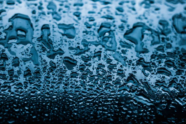 水的质感抽象的背景，水滴落在蓝色的玻璃杯上 — 图库照片