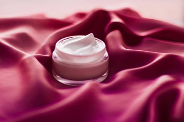 İpek arka planda yüz kremi nemlendirici kavanozu, nemlendirici cilt