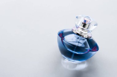 Parlak arka planda mavi parfüm şişesi, tatlı çiçek kokusu, gl