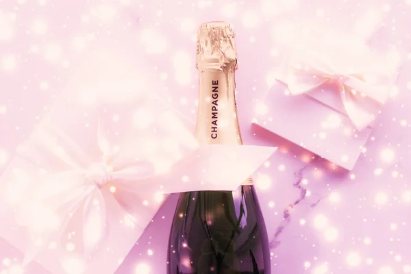 Bouteille de champagne et boîte cadeau sur paillettes de vacances roses, Nouvel An — Photo