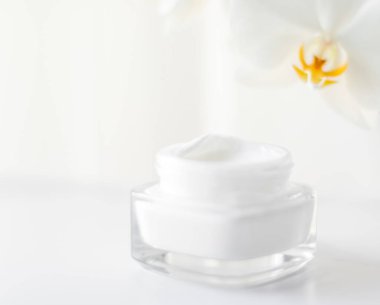 Yüz kremi kavanozu ve orkide çiçeği, nemlendirici cilt 