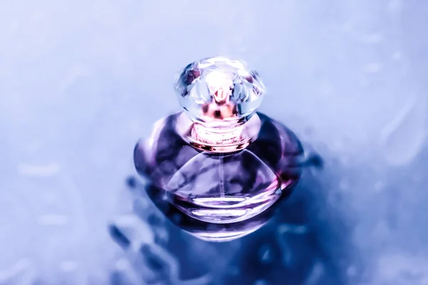 Пляшка парфумів під фіолетовою водою, свіжий морський прибережний аромат як глюк — стокове фото
