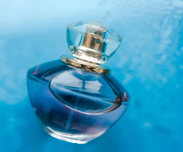 香水瓶在蓝色的水底，新鲜的海滨芬芳扑面而来 — 图库照片