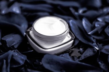 Koyu çiçek torbasında yüz derisi için yüz kremi nemlendirici.