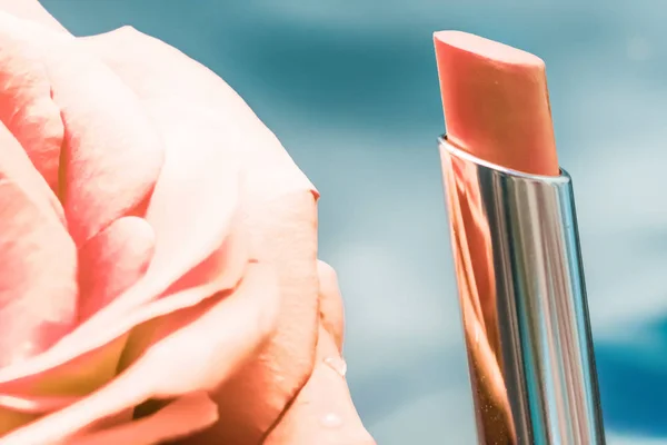 Yellow lipstick and rose flower on liquid background, waterproof