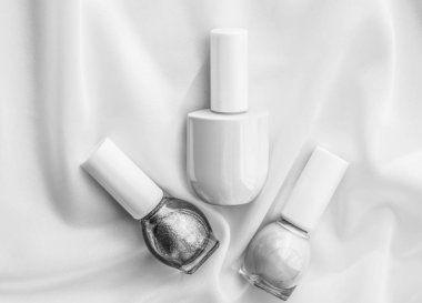 İpek arka planda oje şişeleri, Fransız manikür ürünleri.