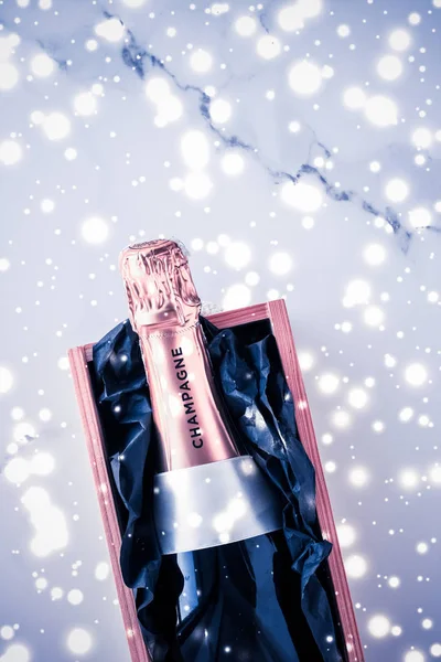 Пляшка шампанського і скринька з подарунками на блакитному святковому вогні, Новий рік. — стокове фото