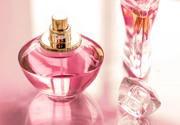 Bottiglia di profumo rosa su sfondo lucido, dolce profumo floreale, gl — Foto Stock