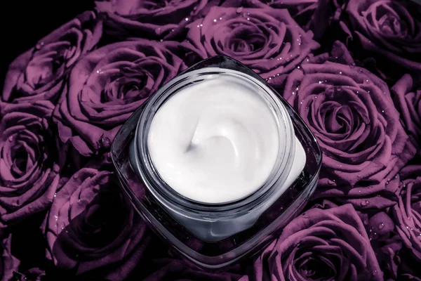 Crema facial hidratante de piel sobre rosas púrpuras flores, piel de lujo —  Fotos de Stock