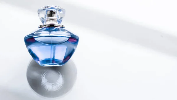 Blue perfume bottle on glossy background, sweet floral scent, gl — Stock Photo, Image
