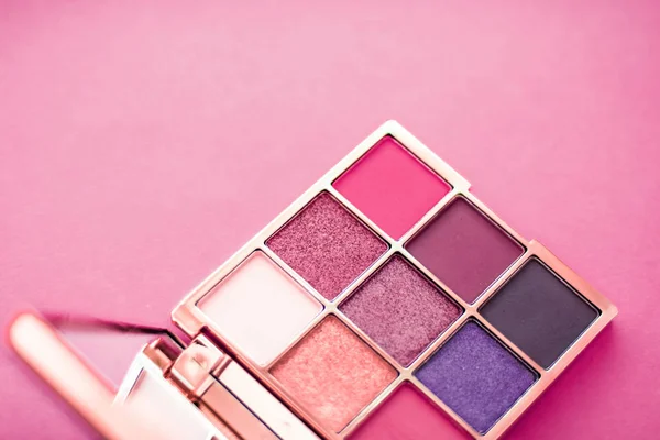 Eyeshadow palette and make-up brush on pink background, eye shad
