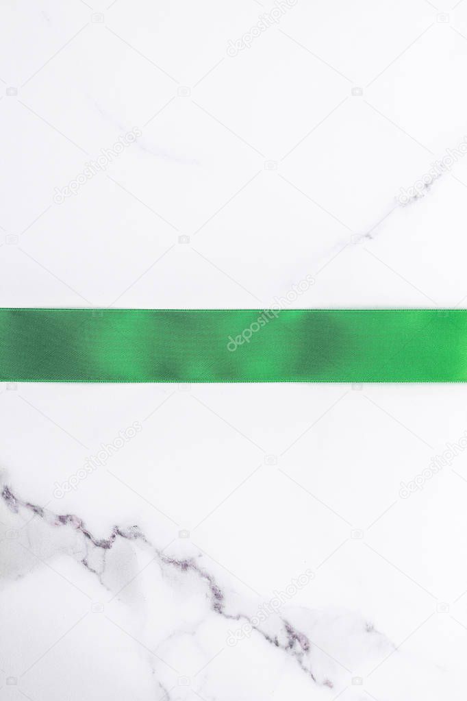 Green silk ribbon and bow on marble background, St Patricks day 