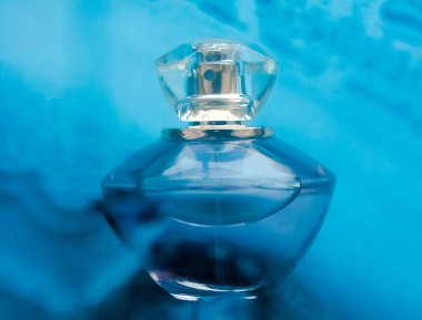 Mavi suyun altında parfüm şişesi, parıltı gibi tatlı deniz kıyısı kokusu.