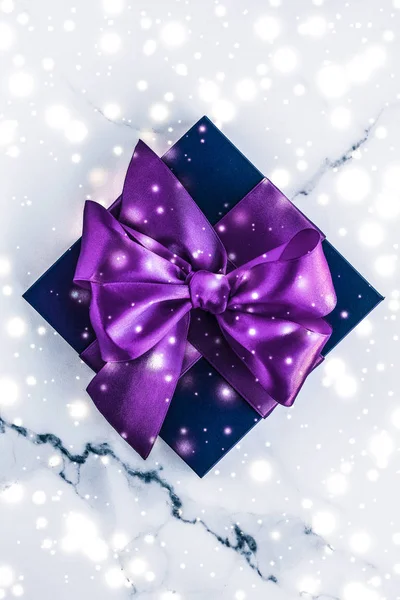 Téli ünnep ajándék doboz lila selyem íj, hó csillogó ma — Stock Fotó
