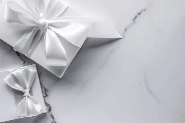 Роскошные свадебные подарки с шелковым луком и лентами на мраморной спине — стоковое фото