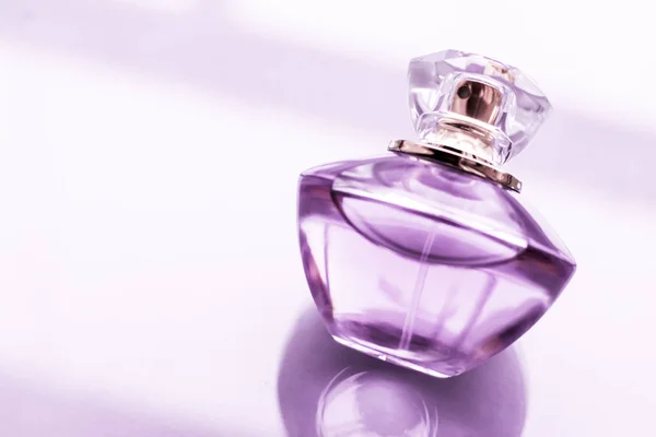 光沢のある背景に紫色の香水瓶、甘い花の香り, — ストック写真