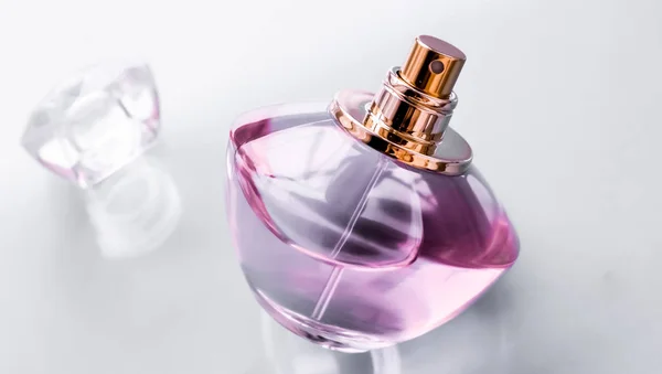 Bottiglia di profumo rosa su sfondo lucido, dolce profumo floreale, gl — Foto Stock