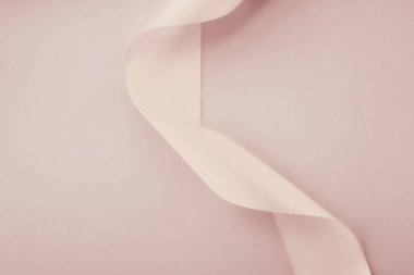 Pastel arka planda soyut kıvrımlı ipek kurdele, özel lüks.
