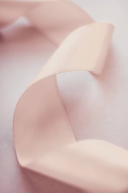 Pastel arka planda soyut kıvrımlı ipek kurdele, özel lüks.