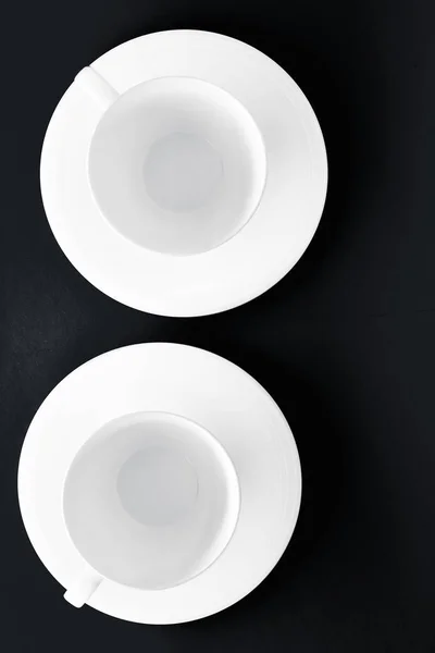 Ensemble de vaisselle en vaisselle blanche, tasse vide sur fond plat noir — Photo