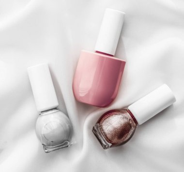 İpek arka planda oje şişeleri, Fransız manikür ürünleri.