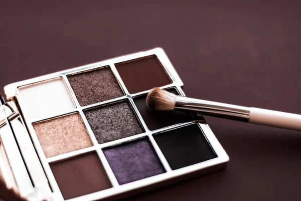 Eyeshadow palette and make-up brush on chocolate background, eye — Stock Photo, Image
