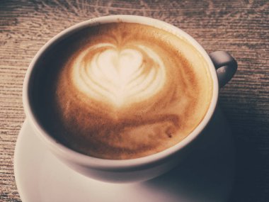 Bir kafeteryasıcak kapuçino Fincan, ahşap bir masada kahve i