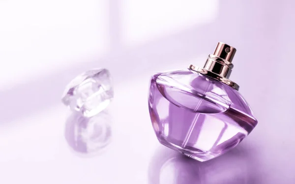 Parlak arka planda mor parfüm şişesi, tatlı çiçek kokusu., — Stok fotoğraf