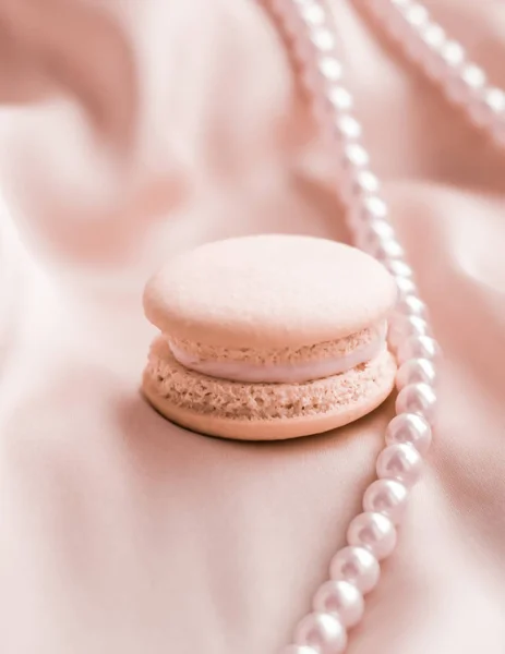 Sweet macaroons and pearls jewellery on silk background, parisia — ストック写真