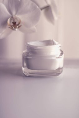 Yüz kremi kavanozu ve orkide çiçeği, nemlendirici cilt 