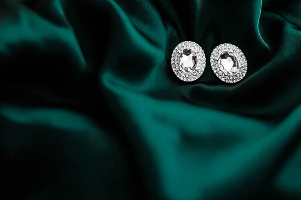 Pendientes de diamantes de lujo en seda verde esmeralda oscura, glamour navideño —  Fotos de Stock