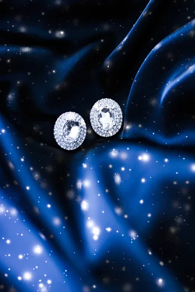 Lyxiga diamantörhängen på mörkblå siden med snöglitter, Hol — Stockfoto