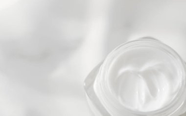 İpek arka planda yüz kremi nemlendirici kavanozu, nemlendirici cilt