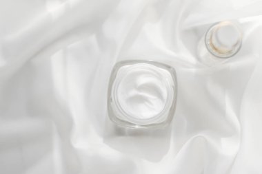 Yüz kremi, nemlendirici kavanoz ve beyaz ipeğe serum jeli, deri araba.