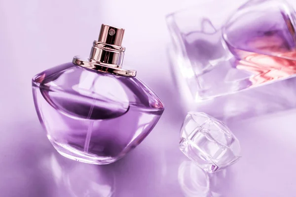Фиолетовый флакон духов на глянцевом фоне, сладкий цветочный аромат , — стоковое фото