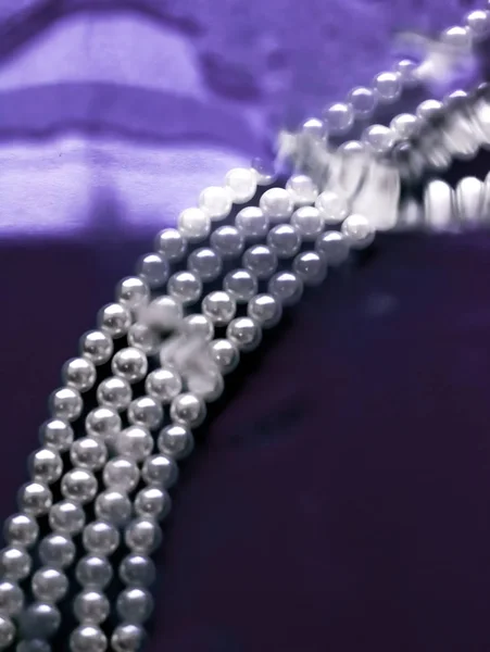 Coastal jewellery fashion, pearl necklace under purple water bac