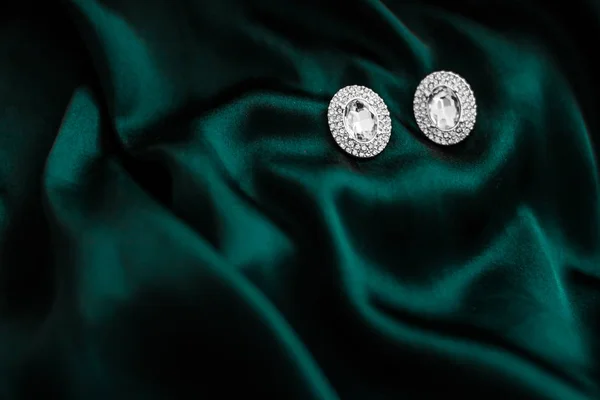 Pendientes de diamantes de lujo en seda verde esmeralda oscura, glamour navideño —  Fotos de Stock