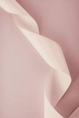 Pastel arka planda soyut kıvrımlı ipek kurdele, özel lüks.