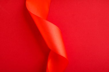 Kırmızı arka planda soyut kıvrımlı ipek kurdele, özel lüks b