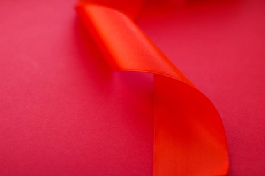 Kırmızı arka planda soyut kıvrımlı ipek kurdele, özel lüks b