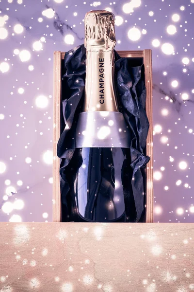 Bouteille de champagne et boîte cadeau sur des paillettes de vacances violettes, New Yea — Photo
